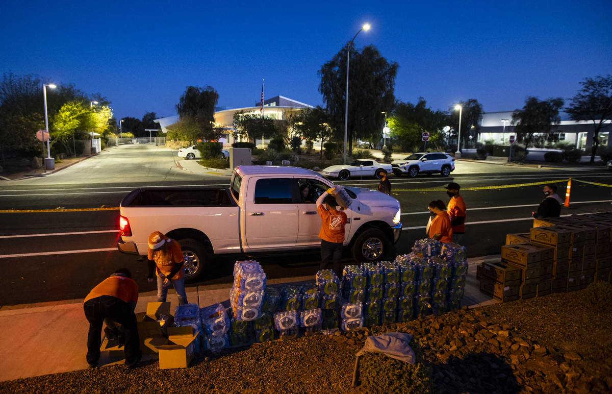 Volunteers with Home Depot deliver cases of water along with meals, holiday decorating kits, ha ...