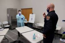 Travis Haldeman, a Clark County Fire Department engineer, uses a nasal swab for a COVID-19 test ...
