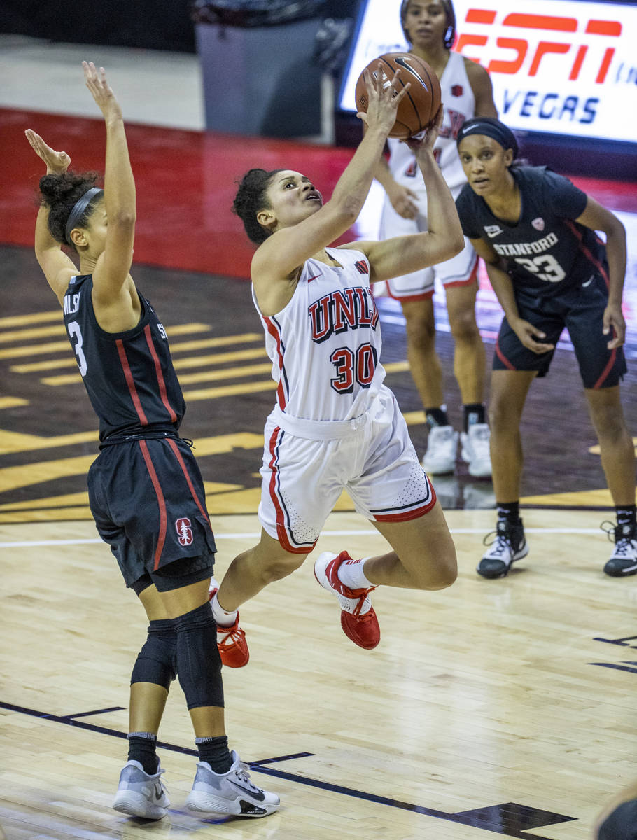 UNLV Lady Rebels guard Nia Johnson (30, center) eyes a shot after passing by Stanford Cardinal ...