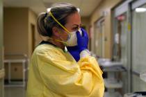 In a Nov. 24, 2020, file photo, registered nurse Chrissie Burkhiser puts on personal protective ...