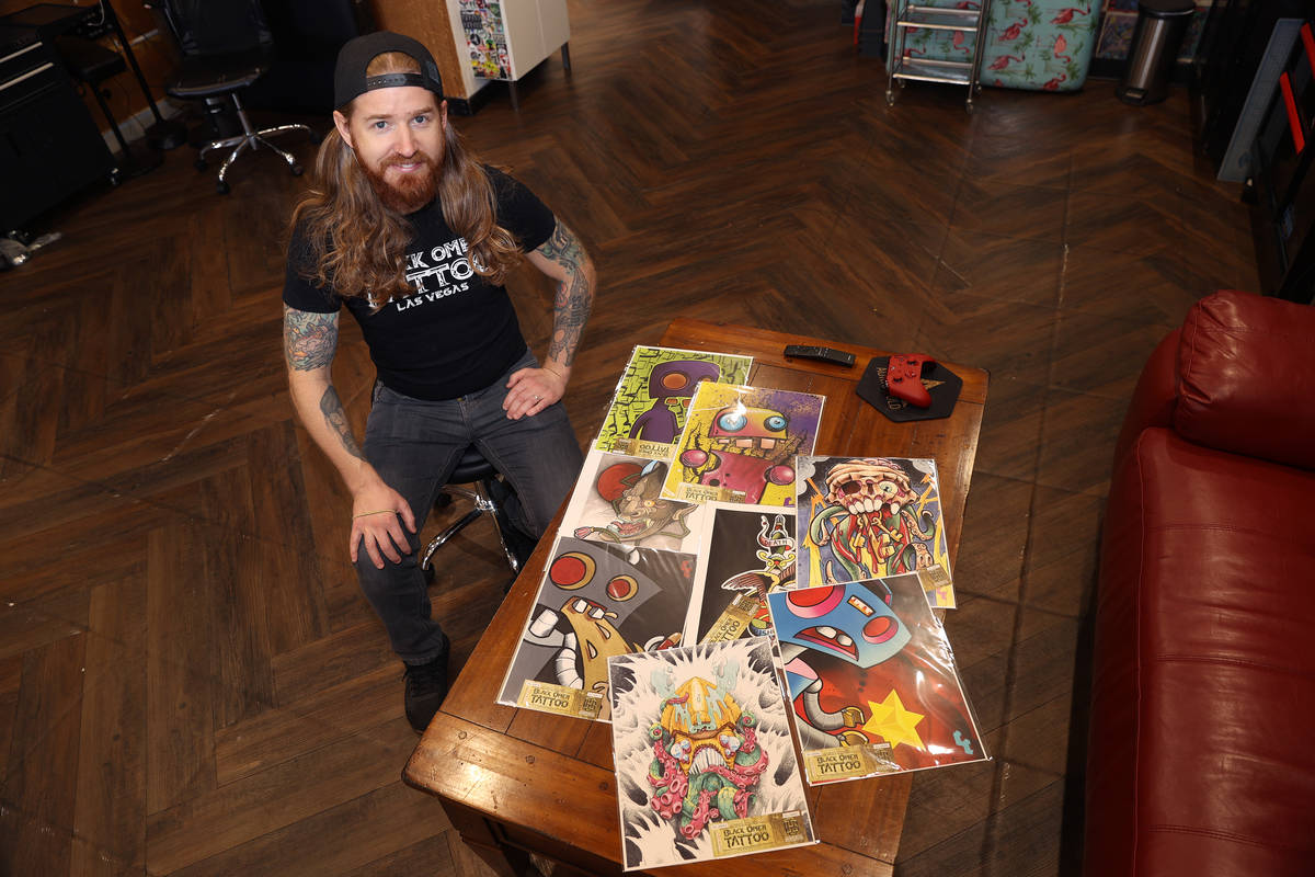 Caleb Cashew, owner of Black Omen Tattoo, shows artwork that contain a raffle ticket for his La ...