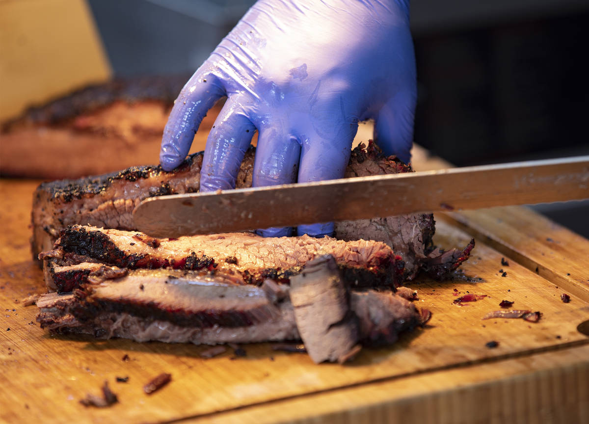 Chef and owner Bruce Kalman cuts brisket at the SoulBelly BBQ pop-up in the Arts District in La ...