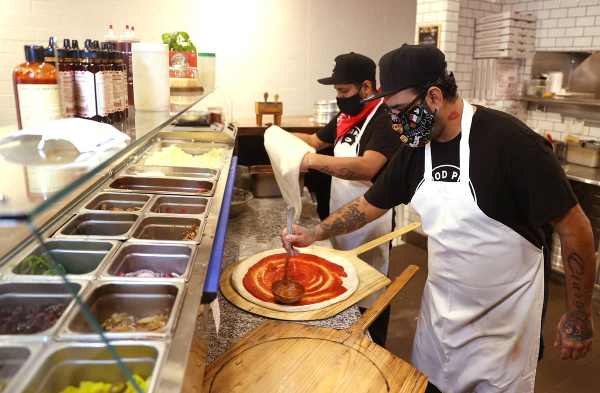Giovani Ortiz, left, and G. Perez make pizzas at Good Pie restaurant in the Arts District in do ...