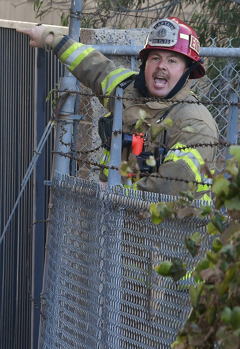A Riverside County fire captain yells for firefighters to advance their hose line as they battl ...