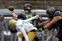 Oregon's Tyler Shough throws down field under pressure from UCLA's Elisha Guidry during the sec ...