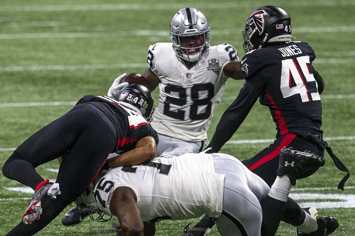 Las Vegas Raiders running back Josh Jacobs (28) runs for more yards against Atlanta Falcons lin ...