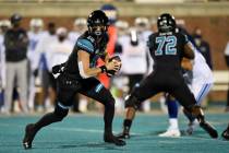Coastal Carolina quarterback Grayson McCall, left, scrambles during the first half of an NCAA c ...