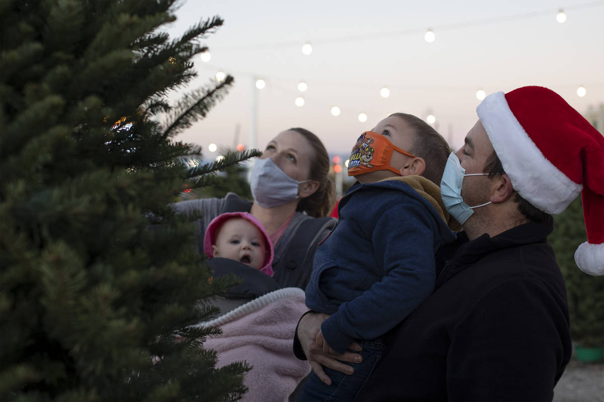 JT Carroll holds his son Luke Carroll, 3, alongside his wife Jen Carroll and their daughter Mag ...