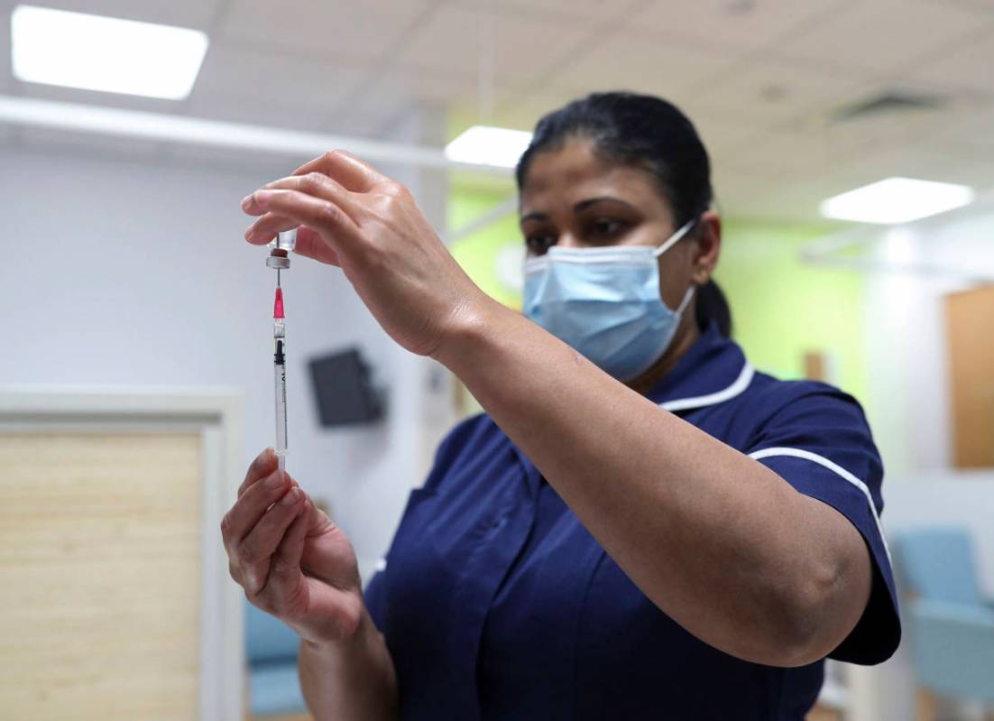 A nurse at the Royal Free Hospital, simulates the administration of the Pfizer vaccine to suppo ...