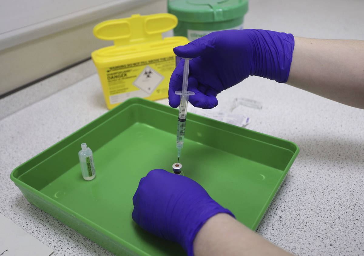 A NHS pharmacy technician at the Royal Free Hospital, simulates the preparation of the Pfizer v ...