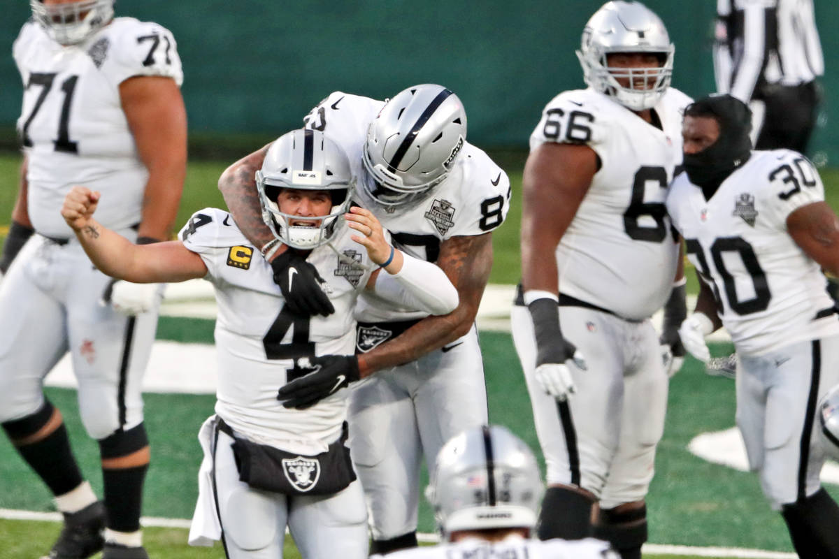 Las Vegas Raiders quarterback Derek Carr (4) celebrate after throwing a touchdown pass to Henry ...