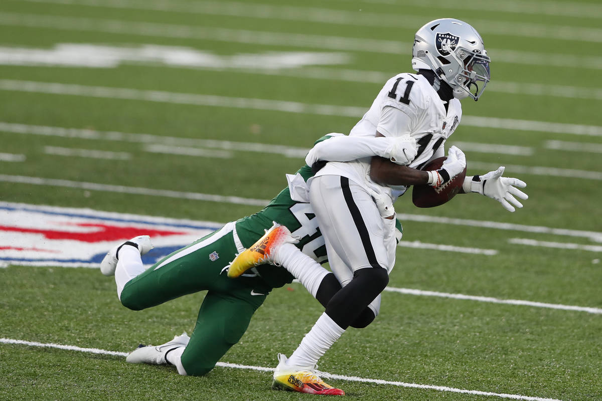 New York Jets' Javelin Guidry, left, forces a fumble by Las Vegas Raiders' Henry Ruggs III duri ...