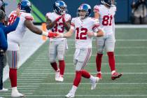 New York Giants defensive lineman Austin Johnson celebrates with quarterback Colt McCoy (12) af ...