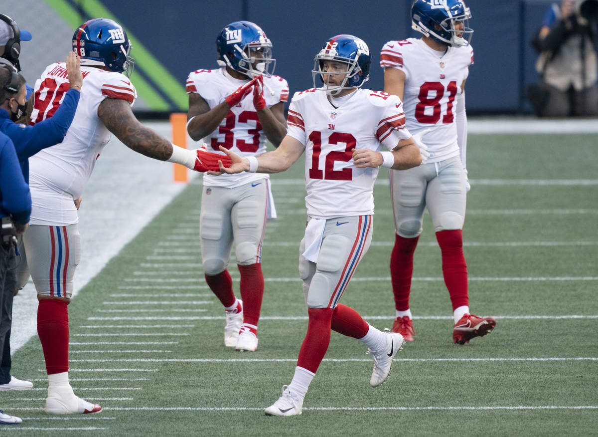 New York Giants defensive lineman Austin Johnson celebrates with quarterback Colt McCoy (12) af ...