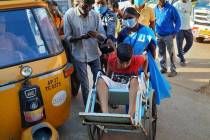 A young patient is brought in a wheelchair to the district government hospital in Eluru, Andhra ...