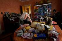 Phyllis Marder poses with her cat, Nellie, with food she recently obtained from a local food ba ...