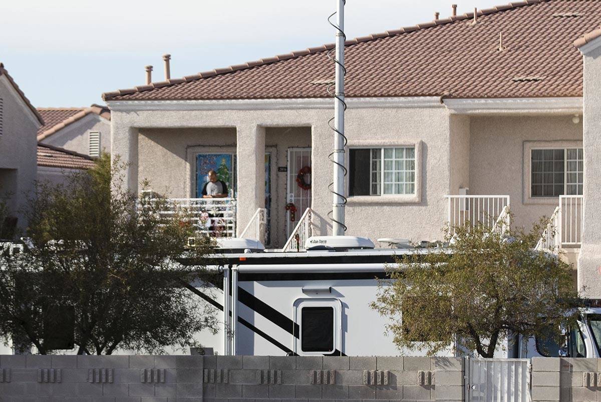 A resident at an apartment complex watches as the North Las Vegas police investigate a possible ...