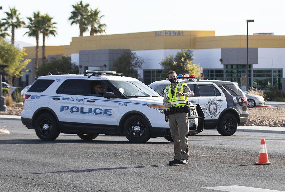 A Metropolitan Police Department officer directs traffic as North Las Vegas police investigate ...