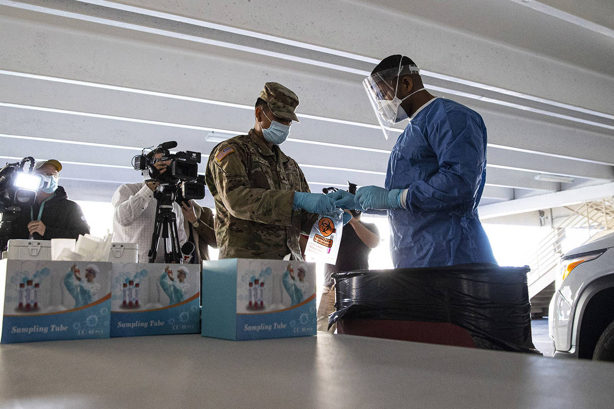 Nevada National Guard specialists Jonathan Macias, left, and Demetrie Barnett store a test tube ...