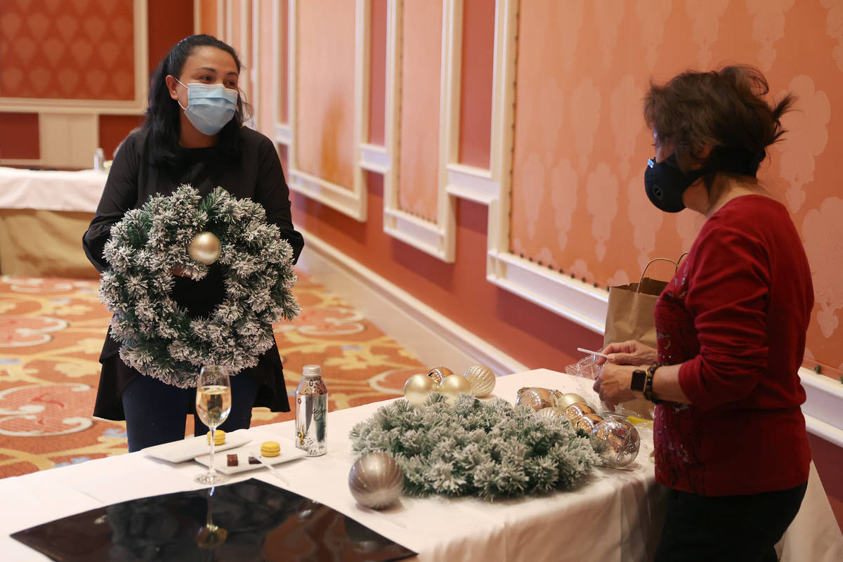Evelyn Herrera, assistant director of horticulture and floral, assists Addie Carpio of Las Vega ...