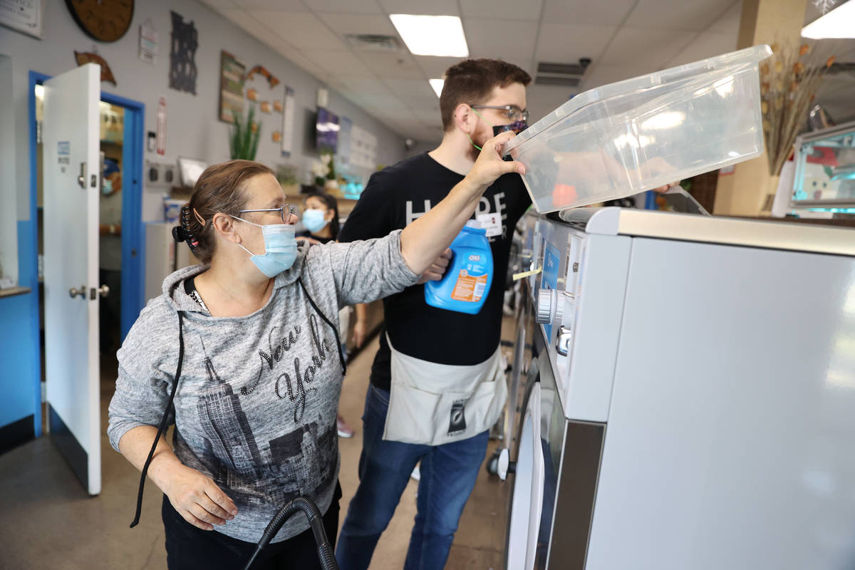 Tiffany Darrel of Las Vegas, left, does her laundry free of charge with the assistance of Corey ...