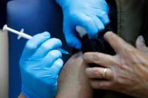 A nurse administers the Pfizer-BioNTech COVID-19 vaccine at Guy's Hospital in London, Tuesday, ...