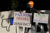 A demonstrator joins others outside of the home of Facebook CEO Mark Zuckerberg to protest what ...