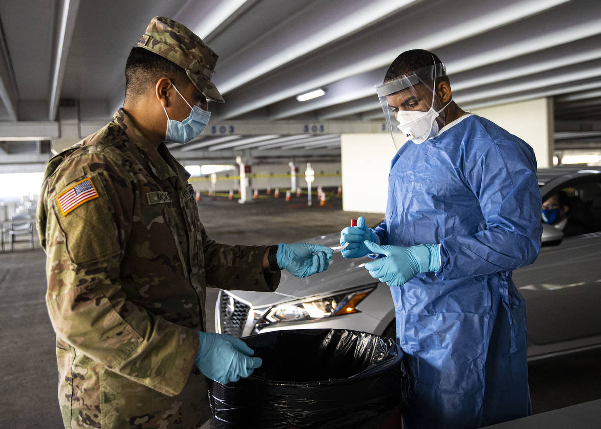 Nevada National Guard specialists Jonathan Macias, left, and Demetrie Barnett prepare to store ...