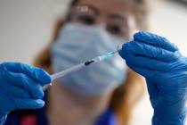 A nurse prepares a shot of the Pfizer-BioNTech COVID-19 vaccine at Guy's Hospital in London, Tu ...