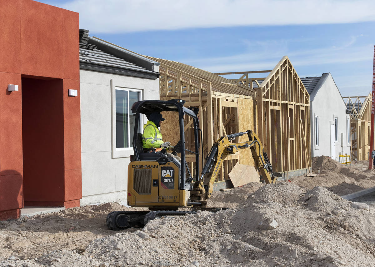 A construction worker digs the ground at Moderne at Centennial construction site where single-s ...