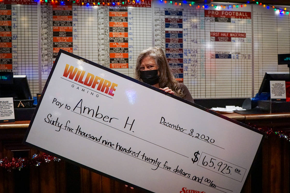Amber Hanover holds up her check for winning the Station Casinos NFL Last Man Standing Contest. ...