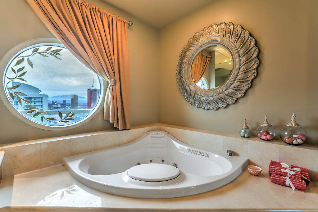 The master bathroom's soaking tub has sweeping views of the Las Vegas Strip from the top floor ...