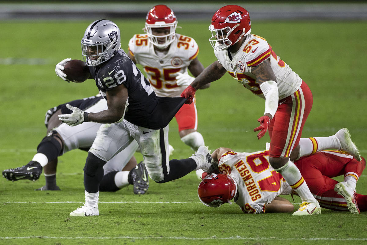 Las Vegas Raiders running back Josh Jacobs (28) runs past Kansas City Chiefs inside linebacker ...