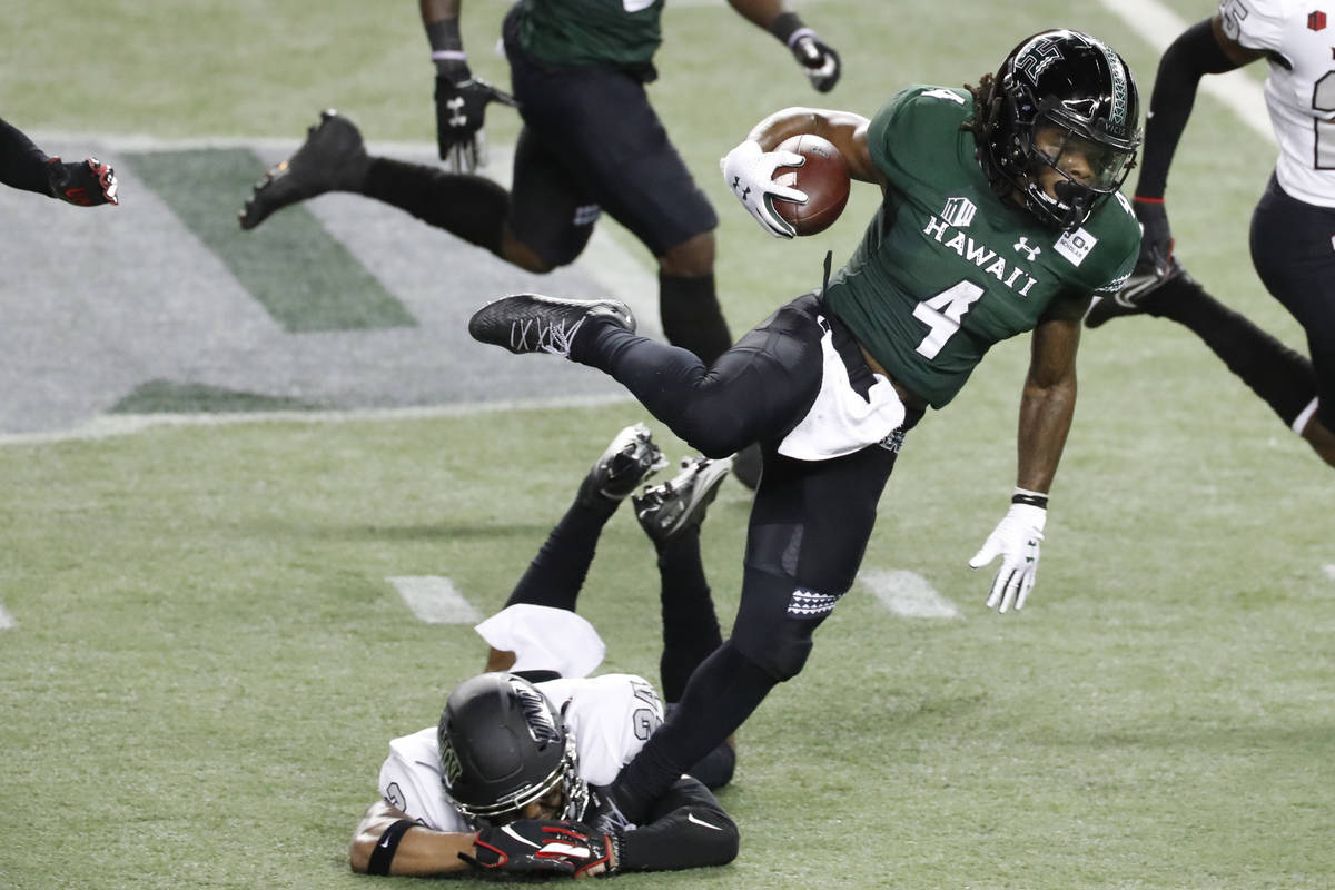 UNLV defensive back Bryce Jackson (24) trips Hawaii running back Miles Reed (4) during the firs ...