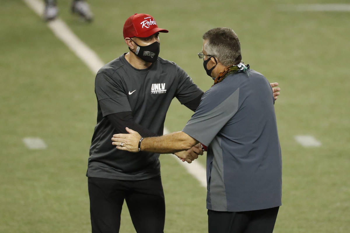 UNLV head coach Marcus Arroyo, left, shakes hands with Hawaii head coach Todd Graham at the end ...