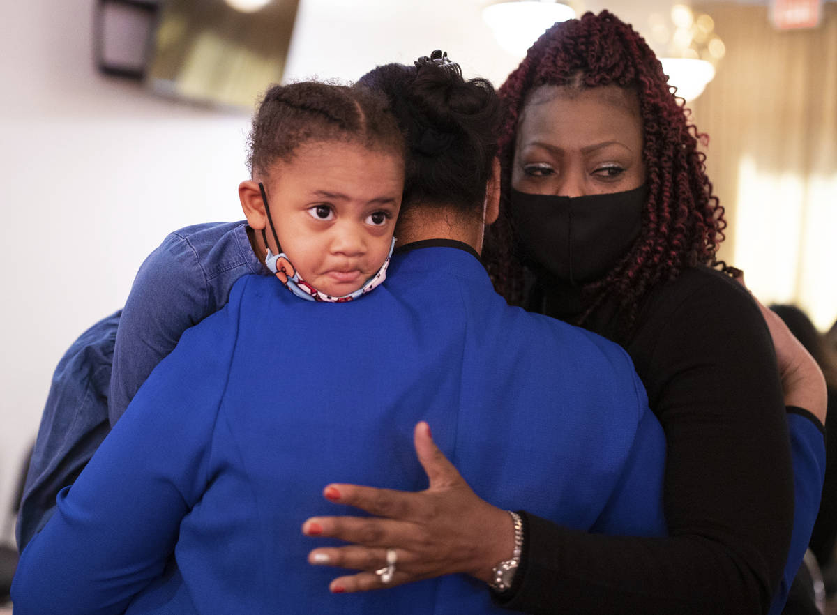 Carolyn Dauphine, right, consoles Evelini Gibbs and Tiye Egypt, 2, during a memorial service fo ...