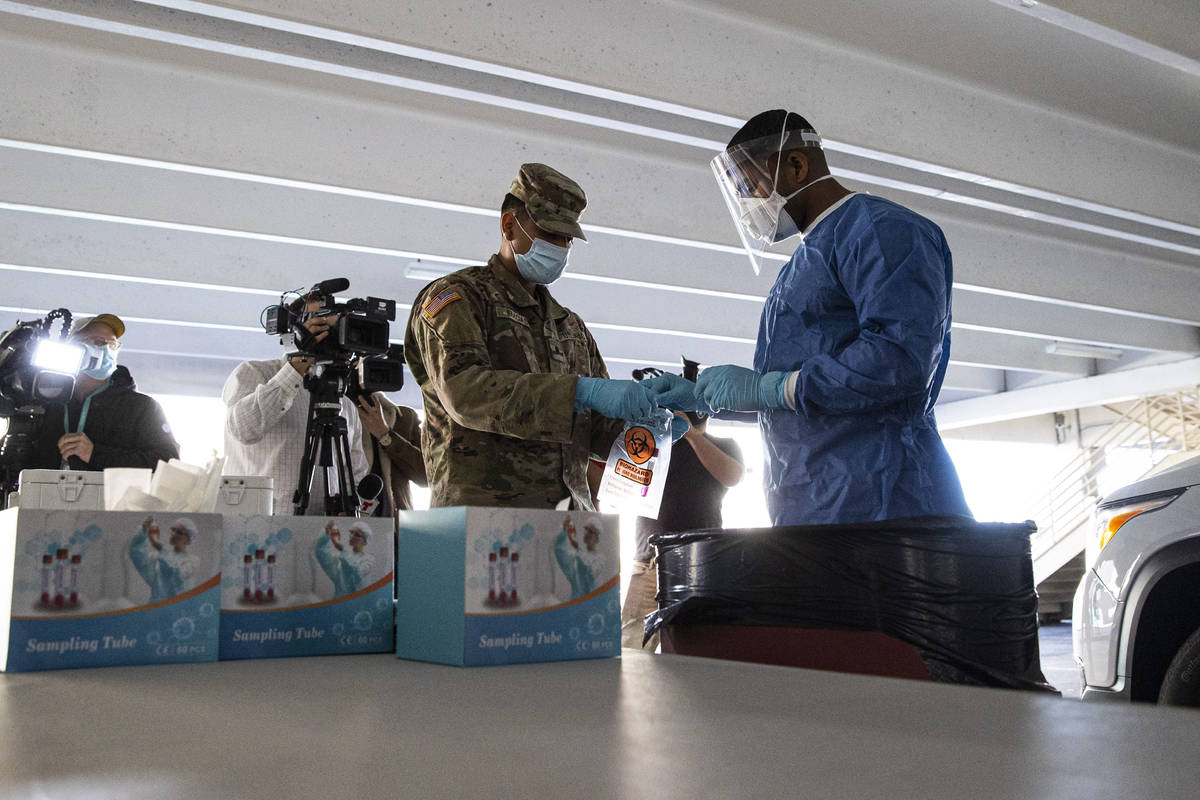 Nevada National Guard specialists Jonathan Macias, left, and Demetrie Barnett store a test tube ...