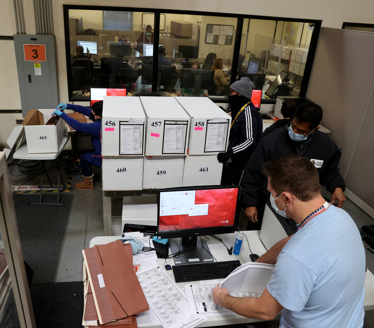 County Election Department staff work on the recount in the Commission District C race between ...