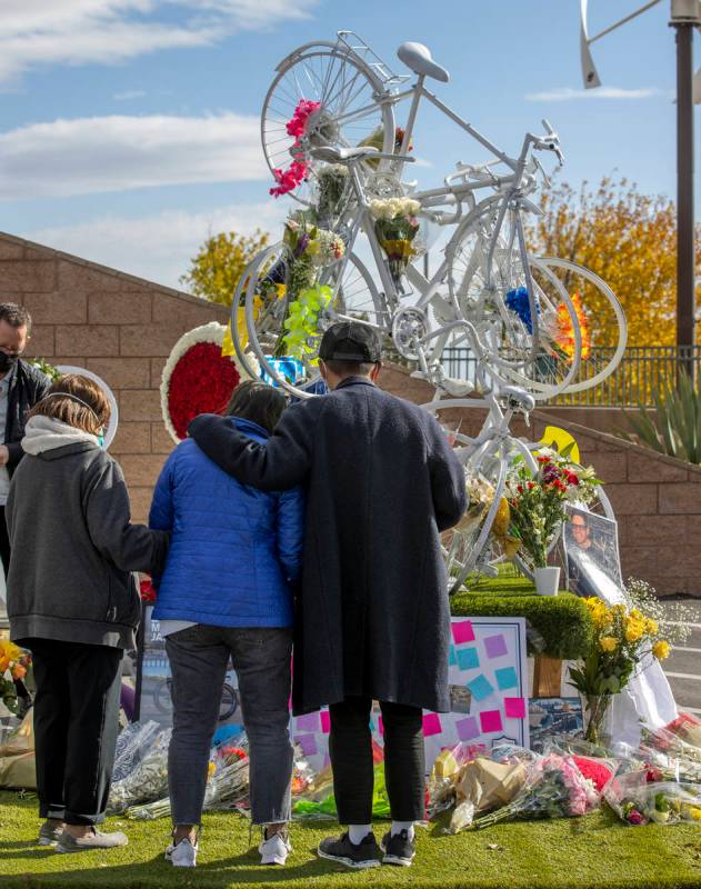 Attendees look to a growing memorial during a vigil honoring the lives of five Las Vegas cyclis ...