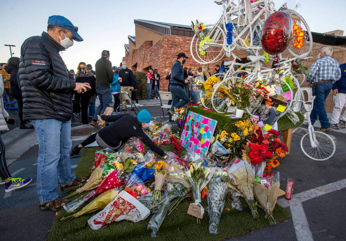 More flowers are added to a memorial during a vigil honoring the lives of five Las Vegas cyclis ...