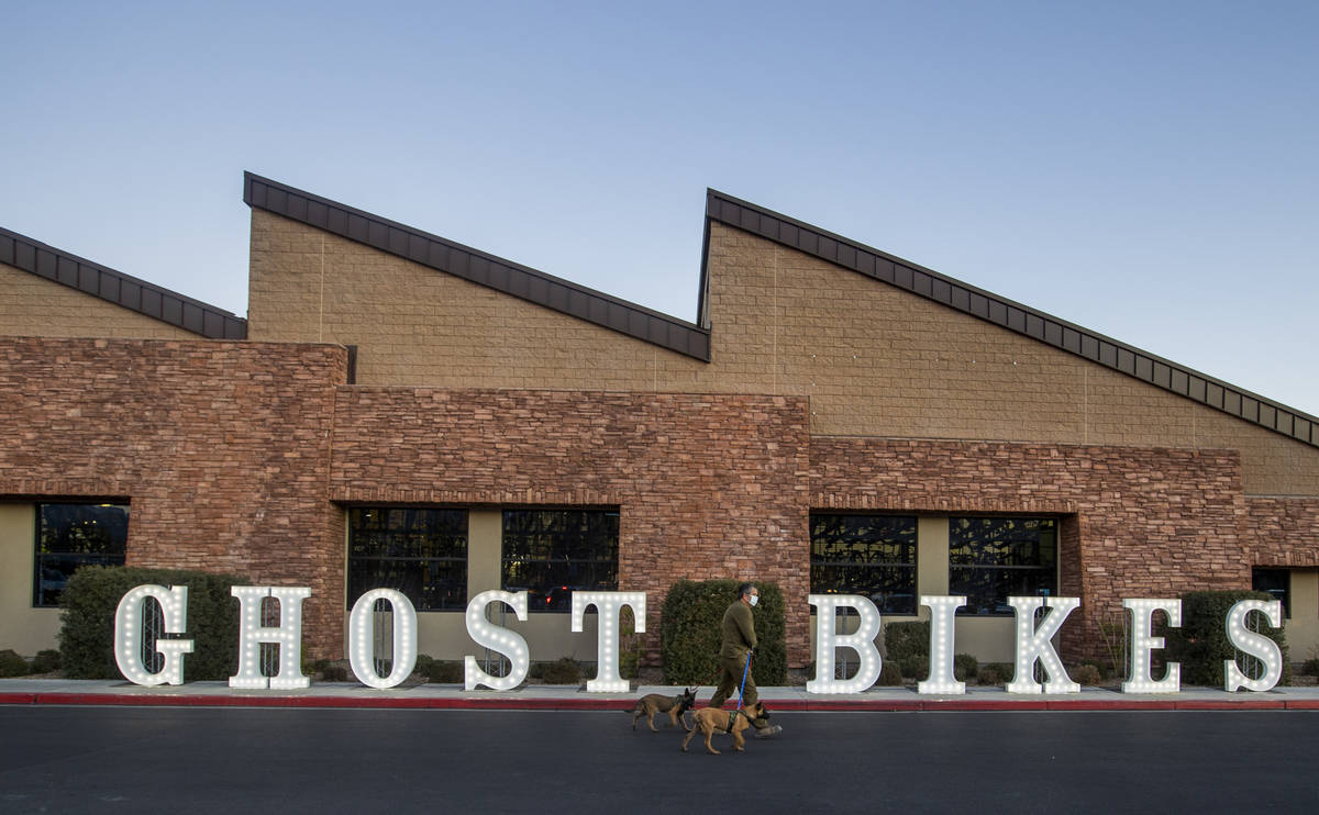 A man walks past a Ghost Bikes sign during a vigil honoring the lives of five Las Vegas cyclist ...