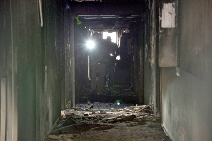 Investigators walk through an interior corridor Dec. 21, 2019 after an early-morning fire at th ...