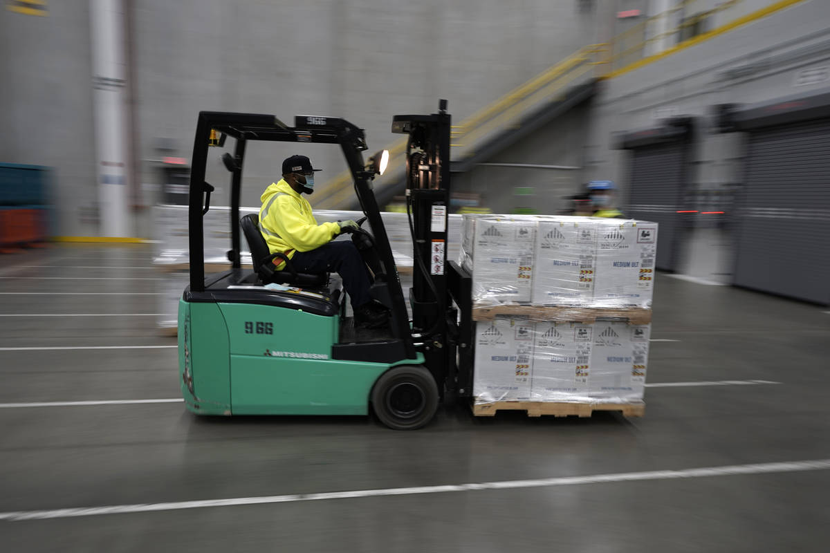 Boxes containing the Pfizer-BioNTech COVID-19 vaccine are brought to to the loading dock for sh ...