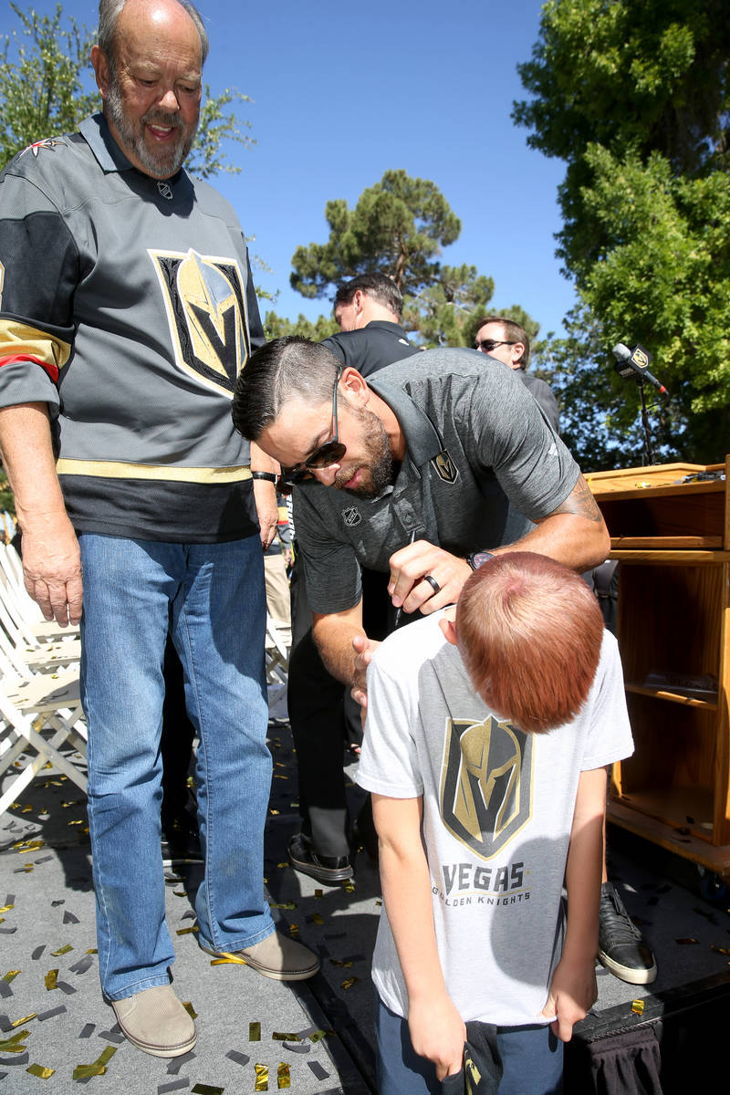Vegas Golden Knights defenseman Deryk Engelland gives an autograph Ryan Griffith, 9, of Henders ...