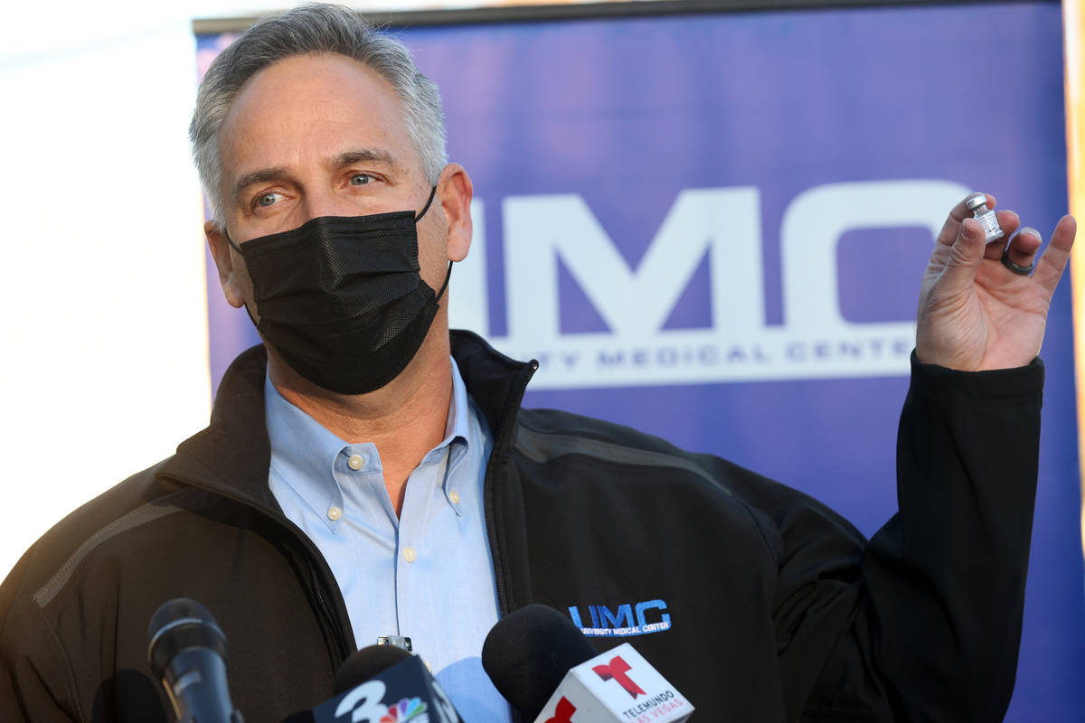 University Medical Center CEO Mason Van Houweling shows the first COVID-19 vaccine administered ...