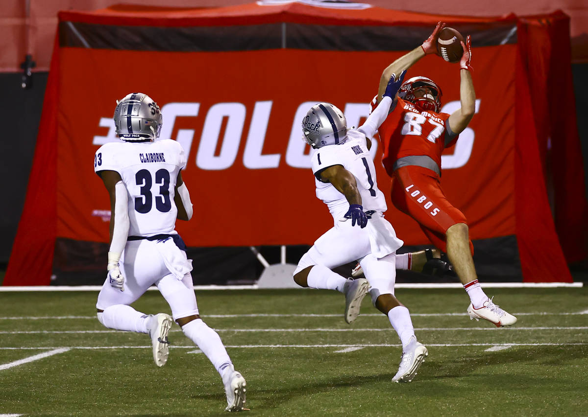 New Mexico Lobos wide receiver Andrew Erickson (87) catches a pass under pressure from UNR Wolf ...