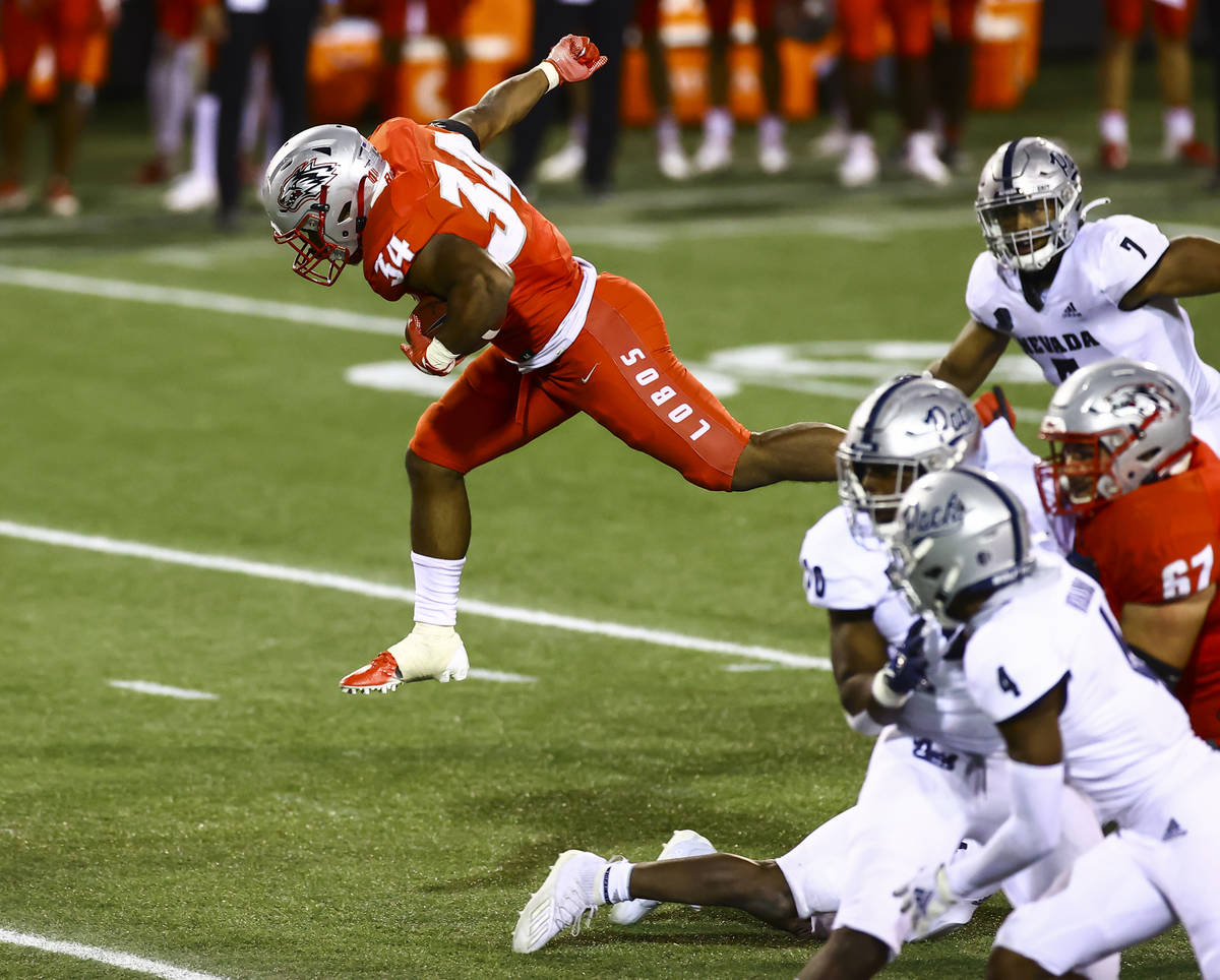 New Mexico Lobos running back Bobby Cole (34) jumps over UNR defenders during the second half o ...