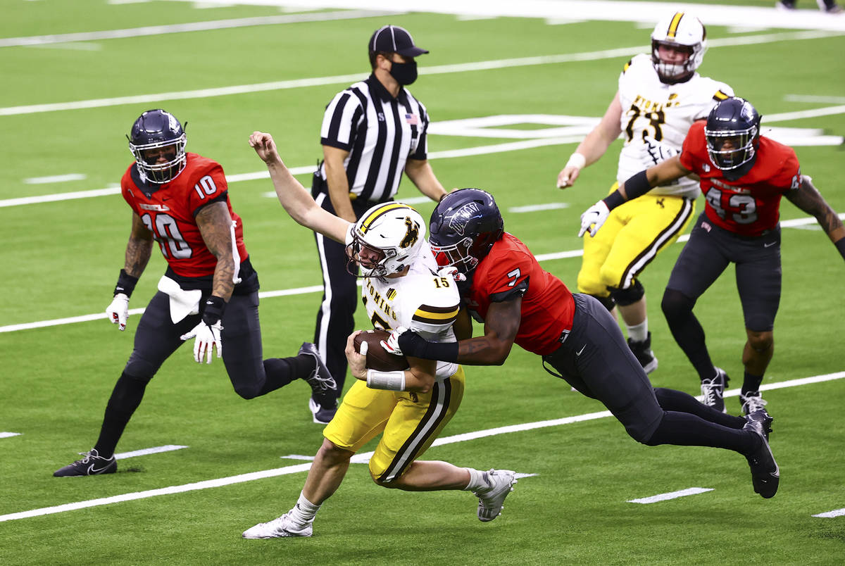 UNLV Rebels defensive lineman Adam Plant Jr. (7) tackles Wyoming Cowboys quarterback Levi Willi ...