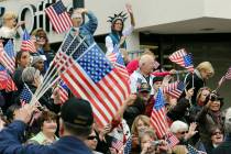 People wave flags at veterans as they watch the Las Vegas Veterans Day Parade. (Las Vegas Revie ...