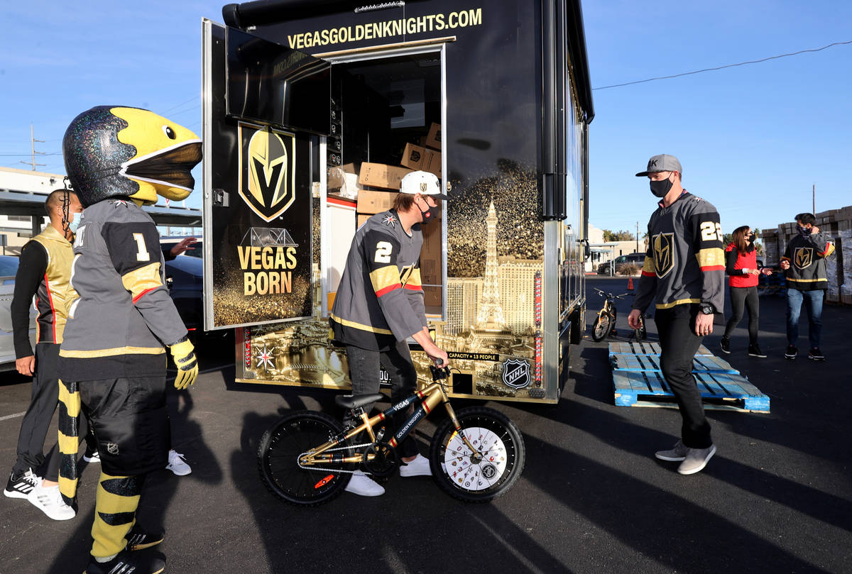 Golden Knights players Zach Whitecloud, from left, Nick Holden and Max Pacioretty unload bikes ...